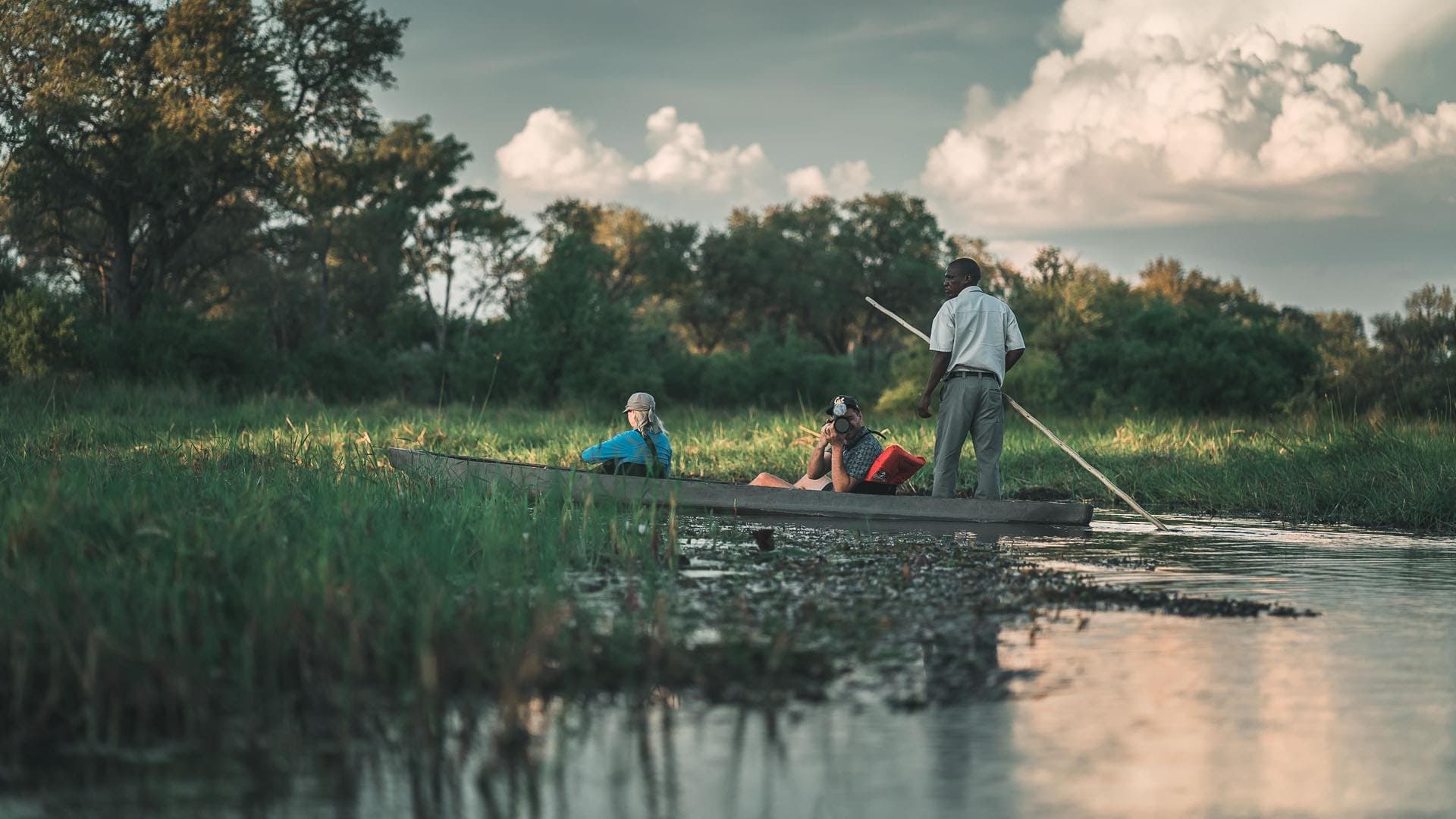 Reisegruppe im Mokoro-Einbaum im Okavango-Delta, Botswana